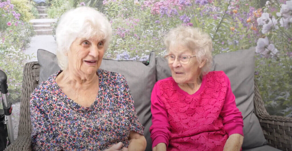 Two ladies talking to camera and smiling